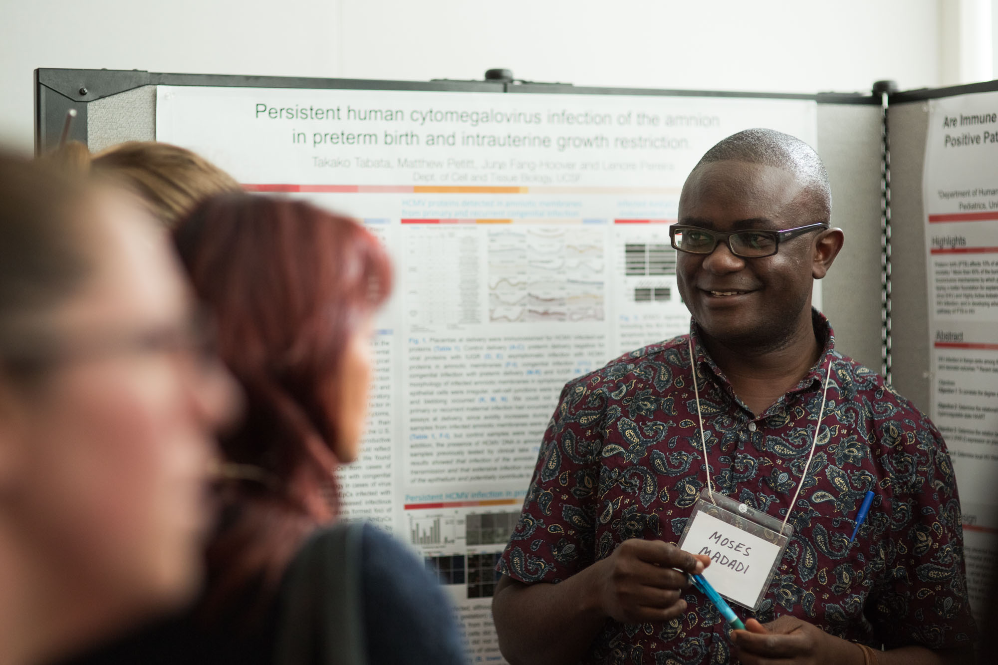 Researchers explaining his poster at the symposium poster session