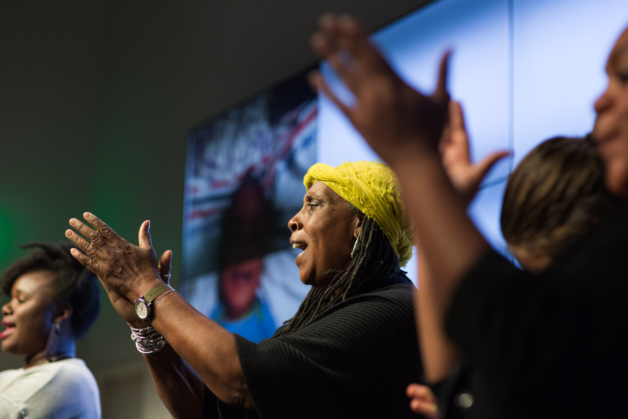 People clapping on stage at symposium