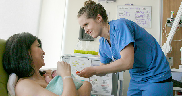 A mother and premature infant in the NICU with a nurse