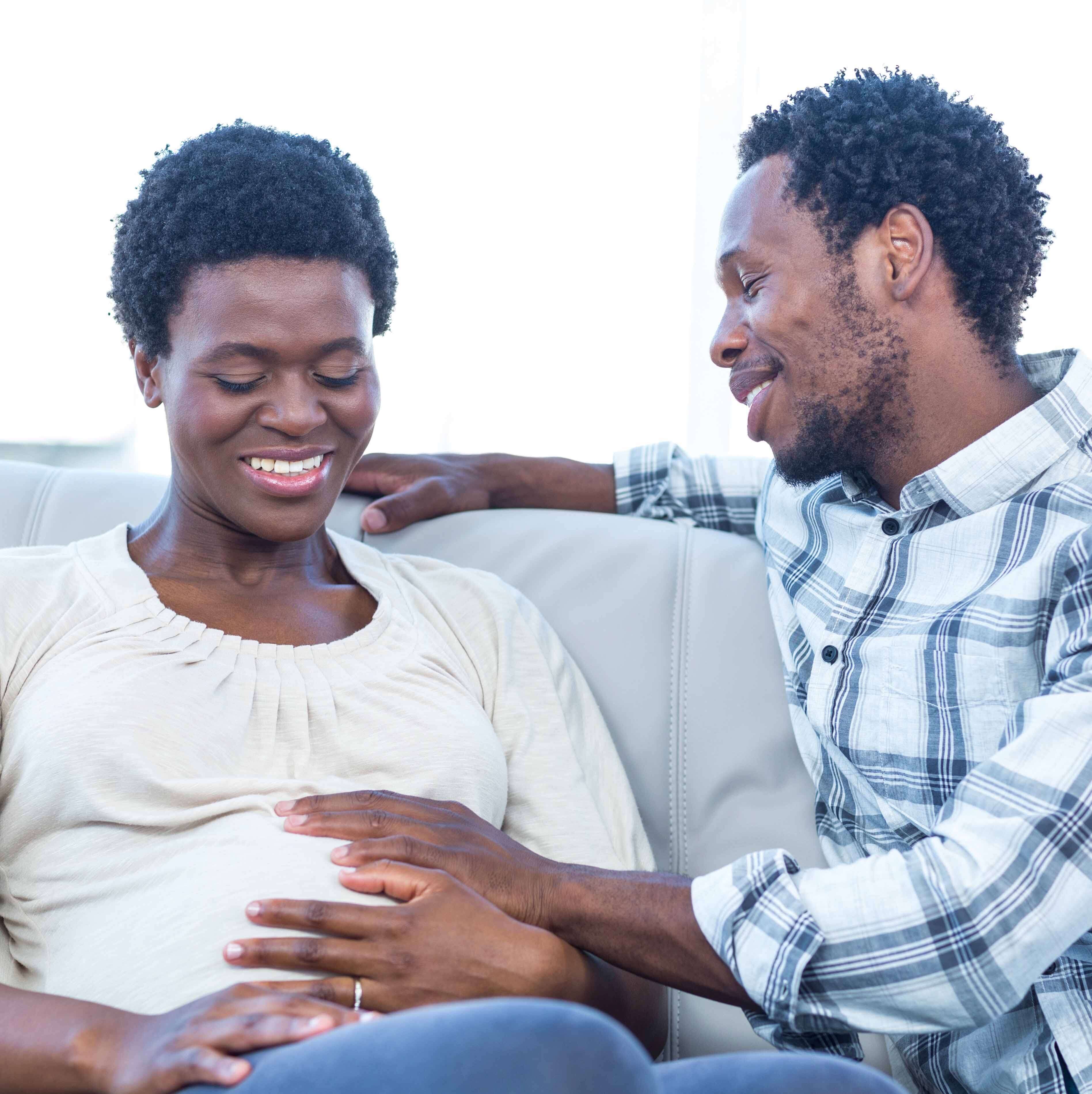 Black mother and father holding the mother's belly 