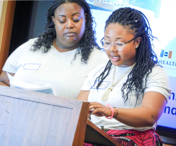 Two BCI fellows at a podium speakubg