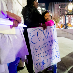 Mom and daughter next to a "Health Equity" sign