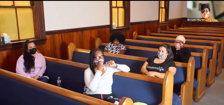 Women sitting in a church discussing the vaccine